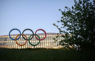Les anneaux olympiques sont vus devant le siège du Comité international olympique (CIO) au coucher du soleil à Lausanne (Photo de FABRICE COFFRINI / AFP via Getty Images)