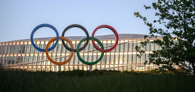 Les anneaux olympiques sont vus devant le siège du Comité international olympique (CIO) au coucher du soleil à Lausanne (Photo de FABRICE COFFRINI / AFP via Getty Images)