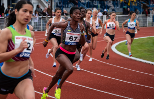 Female athletes competing on running track 