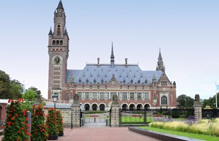 El Palacio de la Paz en La Haya: un edificio de 1900 en ladrillo rojo y blanco, con una torre de reloj alta y estrecha