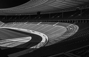 Black and white image of inside an empty sports stadium. 