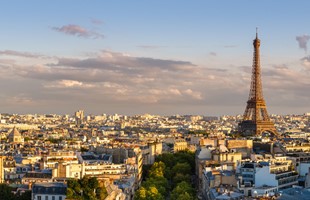 Une vue de Paris depuis un point de vue élevé. La tour Eifel est le point central de l'image à mi-distance.