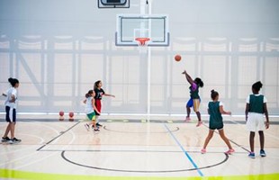Young girls playing on basketball court.