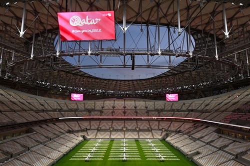 Imagen de un estadio vacío con una gran pantalla que muestra un mensaje que dice Qatar Nos vemos en 2022