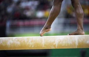 Close up image of athletes feet on balance beam. 