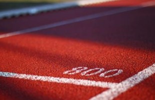 Close up image of white painted lines and number on sports track.